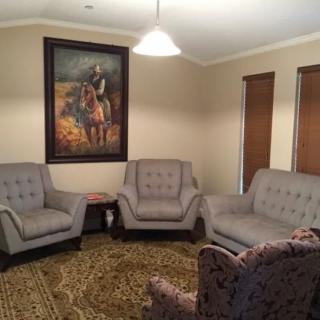 A cozy living room with comfortable seating and a large painting on the wall.