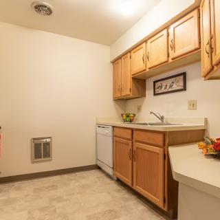 A small kitchen with wooden cabinets and modern appliances.