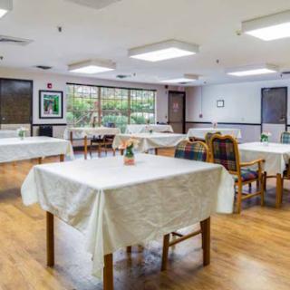 A spacious dining area with neatly set tables and chairs, ready for guests.