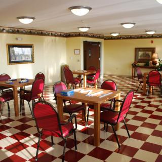 A dining area with red chairs and checkered flooring.