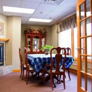 A cozy dining room with a wooden table, surrounded by chairs and decorated with a blue checkered tablecloth.