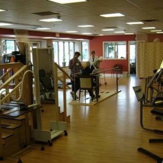 People working out in a fitness center with various exercise equipment.