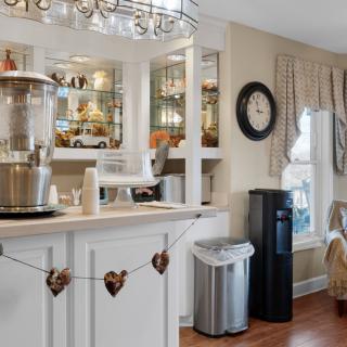 Cozy kitchen interior with a coffee station, mirror backdrop, and decorative elements.