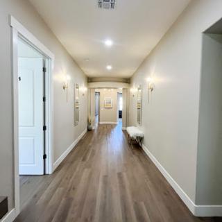 A bright and spacious hallway featuring modern flooring and well-lit walls.