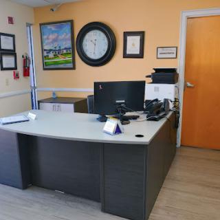 A modern office workspace featuring a desk with a computer and decorative elements on the walls.
