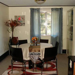 A cozy dining room with a round table, chairs, and decorative elements.