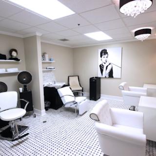 A modern and stylish beauty salon featuring sleek white furniture and elegant decor.