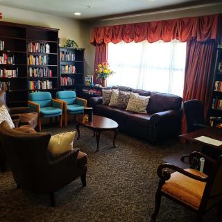 A cozy library with comfortable seating and shelves filled with books.