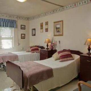 A hospital room with two beds, lamps, and decorative elements on the wall.