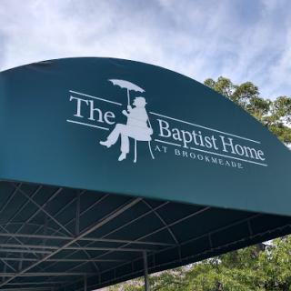 Entrance canopy of The Baptist Home, featuring a logo with a person holding an umbrella.