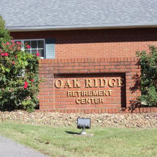 Oak Ridge Retirement Center entrance sign on a brick wall with surrounding landscaping.