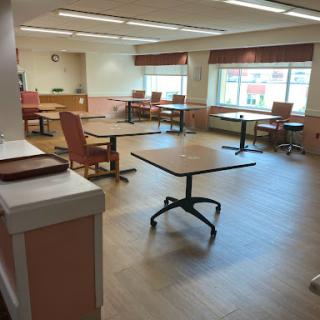 A spacious and bright room with tables and chairs, designed for gatherings or activities.