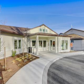 A modern residential building with a circular driveway and landscaped front yard.