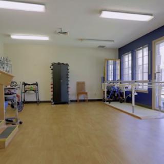 A well-lit physical therapy space equipped with various rehabilitation tools and exercise apparatus.