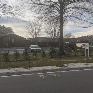 A view of a residential building surrounded by trees and a street.