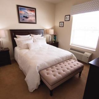 A cozy and elegantly decorated bedroom with a plush bed and soft lighting.