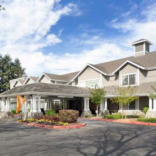 A residential building with a landscaped entrance and clear blue sky.