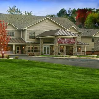 A hotel building with a surrounding landscape of grass and trees.