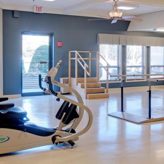 A bright and modern rehabilitation space equipped with exercise equipment and a ballet barre.