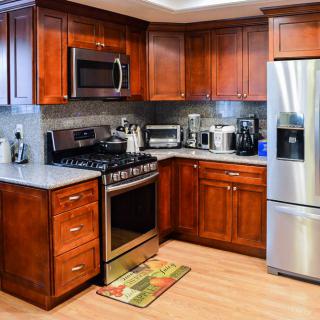 A modern kitchen with wooden cabinets and stainless steel appliances.