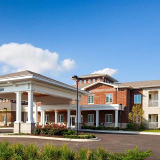 A modern residential building with a spacious entrance and clear blue skies.