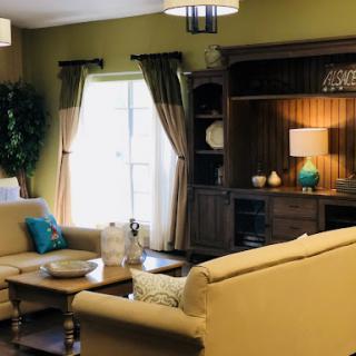 A cozy living room with soft furnishings and warm decor.