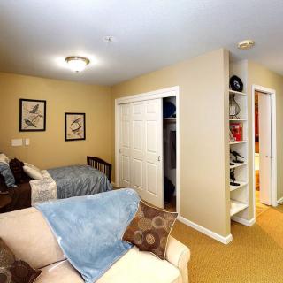 Cozy bedroom with a bed, closet, and shelves.