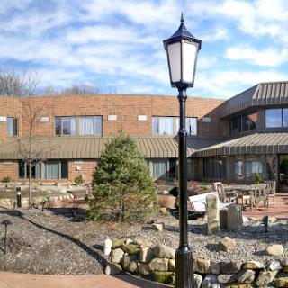 A serene outdoor space featuring a well-maintained garden and a decorative lamp post.