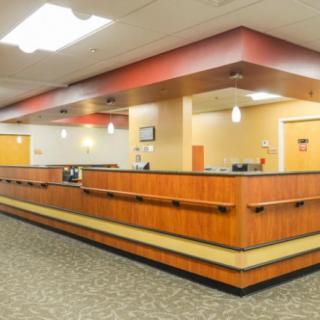 A spacious and well-lit reception area with a large wooden desk.