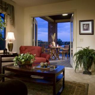 A cozy living room with a view of the balcony at dusk.