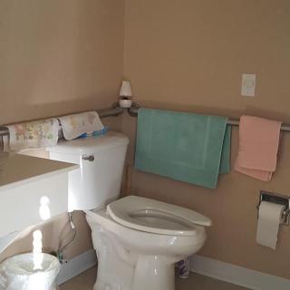 A clean bathroom with a toilet, sink, and towels.