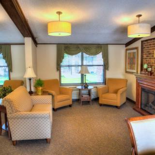 A cozy living room with comfortable seating, a fireplace, and warm lighting.