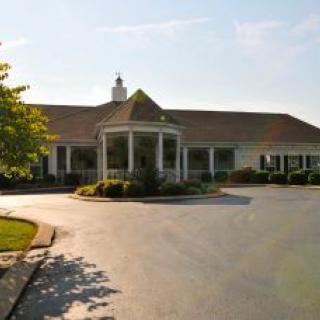 A suburban building with a driveway and landscaped surroundings.