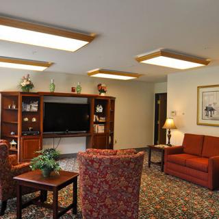 A cozy living room with a television, bookshelves, and comfortable seating.