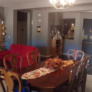 A cozy dining room featuring a wooden table adorned with a decorative centerpiece and surrounded by elegant chairs.