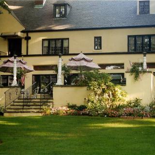 A charming house with a well-maintained garden and outdoor seating area.