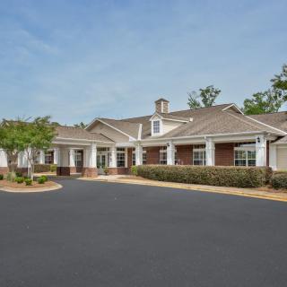 A residential building with a well-maintained driveway and clear blue sky.