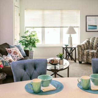 A cozy living room with stylish furniture and decor, featuring a table set with teacups.