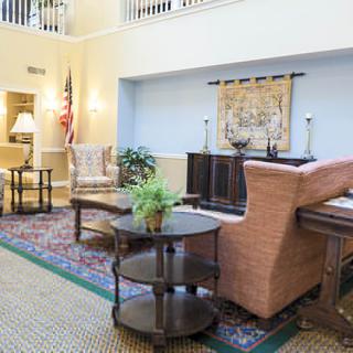 A cozy living room interior with a sofa, armchairs, and decorative elements.