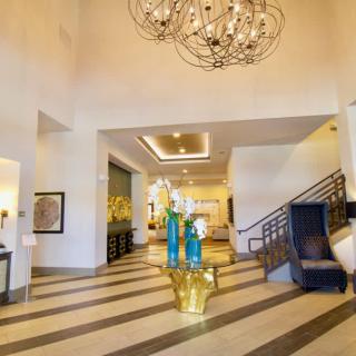 A modern hotel lobby featuring a large chandelier and elegant interior design elements.