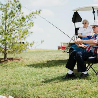 A serene scene of two seniors enjoying a day of fishing in the great outdoors.