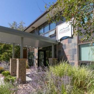 A modern building entrance surrounded by landscaped greenery.