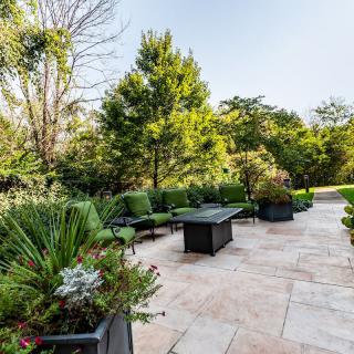 A beautifully landscaped patio garden with seating and lush greenery.