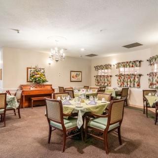 A well-decorated dining area with multiple tables and a piano.