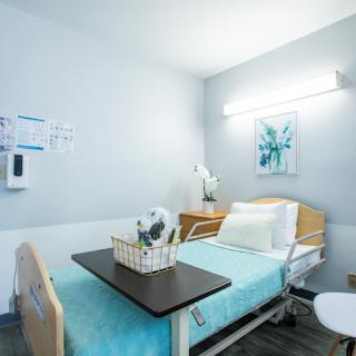 A clean and minimalist hospital room with a medical bed and essential furnishings.