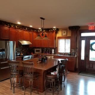 Spacious kitchen with wooden cabinets, a central island, and modern appliances.