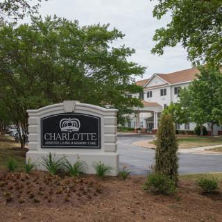 Entrance sign to a residential area with surrounding trees and landscaping.