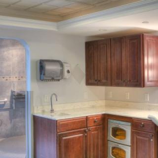 A modern kitchen with wooden cabinets, a countertop, and built-in ovens.
