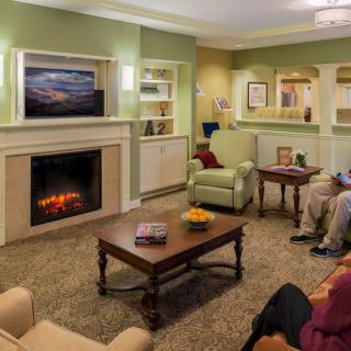 A cozy living room with a fireplace, comfortable seating, and a television.