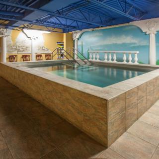 An indoor swimming pool area with a painted mural and tiled surroundings.